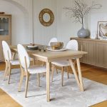 Photo présentant un salon avec une table, un bahut, une vitrine et des chaises. Chaque meuble à une finition en chêne massif blond et une peinture couleur chanvre.