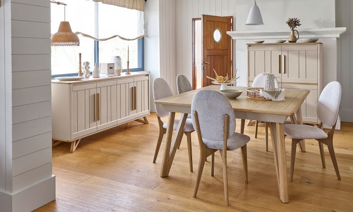 Photo présentant une salle à manger avec une table carré, chaise tissu, un buffet haut et un bahut. Chaque meuble à une finition en chêne massif blond et une peinture couleur argile.