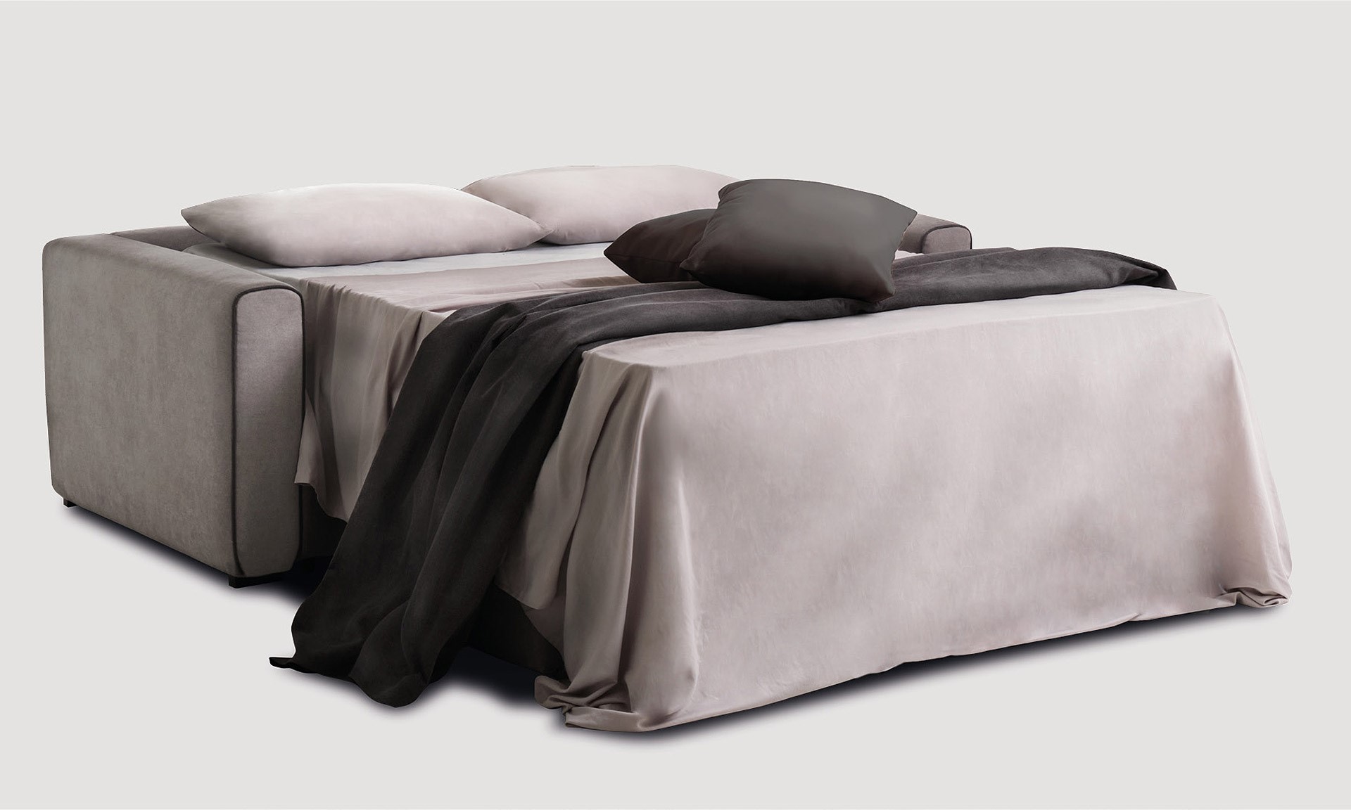 Canapé Convertible 3 places en tissu gris taupe avec passepoil en gris anthracite. Il est ouvert en lit double avec deux coussins gris anthracite.